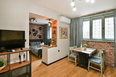 a living room and a dining room with a table at Handmade - central studio in Varna City