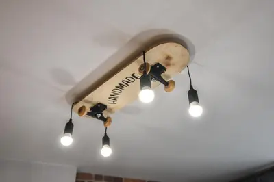 a wooden skateboard hanging from a ceiling with lights at Handmade - central studio in Varna City