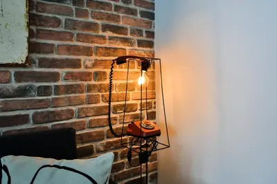 a lamp in front of a brick wall at Handmade - central studio in Varna City