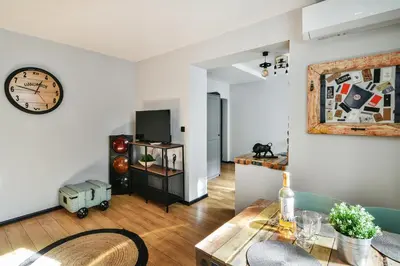 a living room with a table and a clock on the wall at Handmade - central studio in Varna City