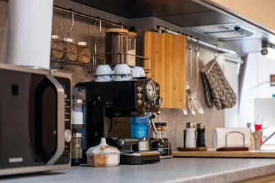 a kitchen counter with a coffee pot on top of a microwave at Seagull Apartment in Varna City