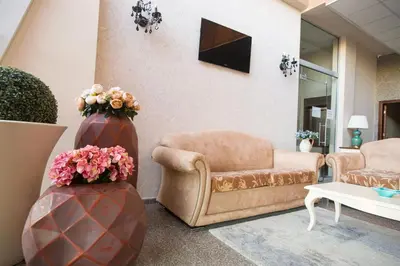 a living room with a couch and a chair and flowers at The Red Lozenets in Lozenets