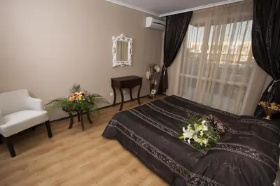 a bedroom with a bed and a chair and a window at The Red Lozenets in Lozenets
