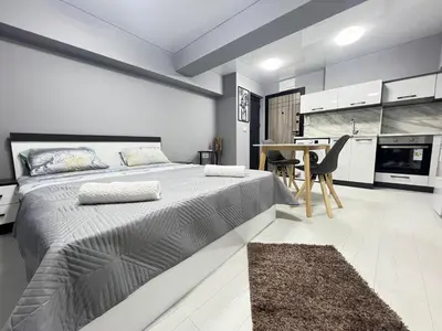 a bedroom with a large bed and a kitchen at NJ bedroom in Varna City