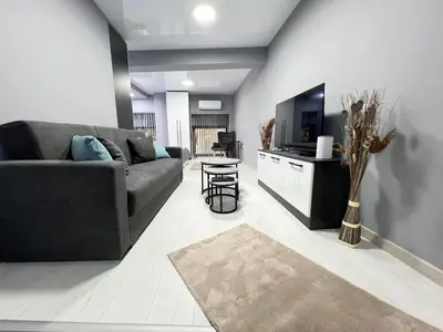 a living room with a couch and a tv at NJ Luxury Room in Varna City
