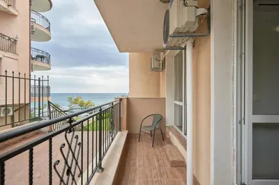 a balcony with a chair looking out at the ocean at Private 1-BD Apartment with Balcony in Sveti Vlas by Flat Mаnаger in Sveti Vlas
