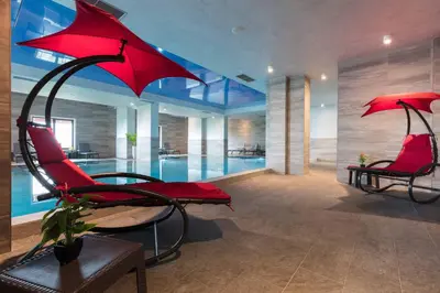 a living room with red chairs and a pool at Burgas Residence 504 l Indoor Parking l Breakfast & SPA available in Burgas City