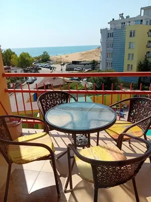 a table and chairs on a balcony with a view of the beach at Златна Дюна - до южния плаж на Несебър in Nesebar