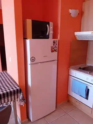 a small kitchen with a refrigerator and a microwave at Златна Дюна - до южния плаж на Несебър in Nesebar