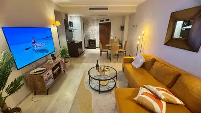 a living room with a couch and a flat screen tv at Luxury sea view, 5star Barcelo on Beach in Sunny Beach