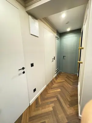a hallway with white walls and wood floors at Kandinski Lux Apart in Burgas City