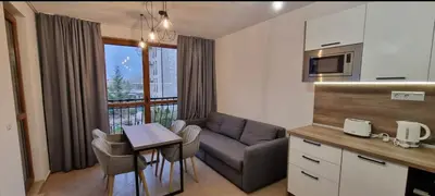 a kitchen and living room with a couch and a table at Luxury Apartments in Cascadas Family Resort Sunny Beach in Sunny Beach