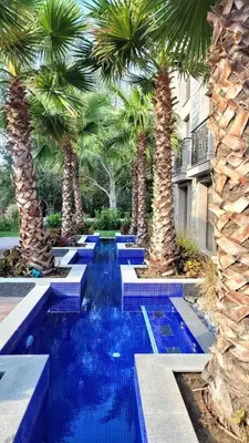 a pool with palm trees and blue water at Luxury Apartments in Cascadas Family Resort Sunny Beach in Sunny Beach