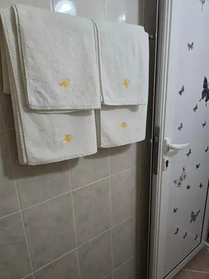 a bathroom with white towels and a shower at Stephanovy Guest House in Sozopol