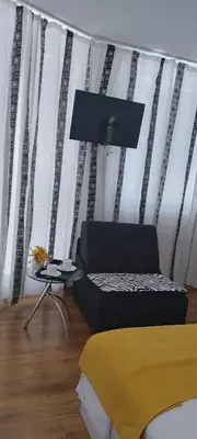 a room with a couch and a chair and a window at Stephanovy Guest House in Sozopol