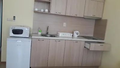 a small kitchen with a sink and a microwave at Stephanovy Guest House in Sozopol