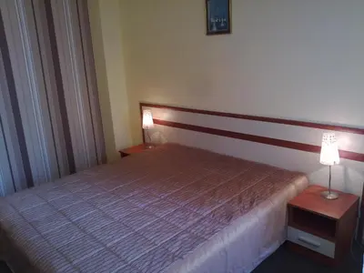 a bedroom with a bed and two lamps on tables at Stella Del Mare Guest House in Kiten