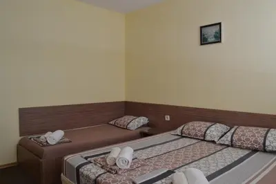 a bedroom with two beds and a couch at Stella Del Mare Guest House in Kiten