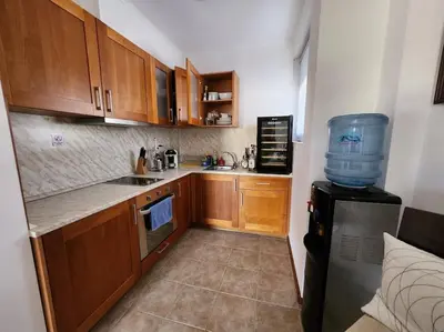 a small kitchen with wooden cabinets and a water cooler at Bay view villas sunny beach entire villa in Kosharitsa