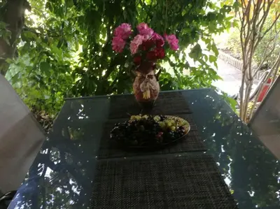 a table with a plate of food and a vase with flowers at Вилла Яна in Sveti Vlas