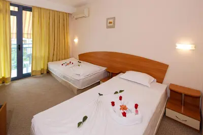 a hotel room with two beds with flowers on them at Paloma - in the center of the city in Sunny Beach