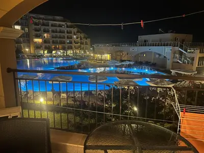 a balcony with a view of a pool at night at Midia Grand Resort Aheloy in Aheloy