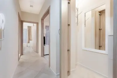 a hallway with white walls and a mirror at АТ apartment - Pool View in Varna City