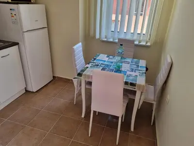 a kitchen with a table with chairs and a refrigerator at Sunny beach family apartment 302, Sluneční pobřeží in Sunny Beach