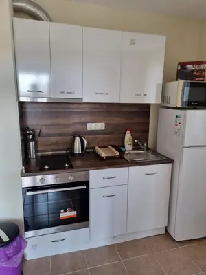 a kitchen with white cabinets and a stove and a refrigerator at Sunny beach family apartment 302, Sluneční pobřeží in Sunny Beach