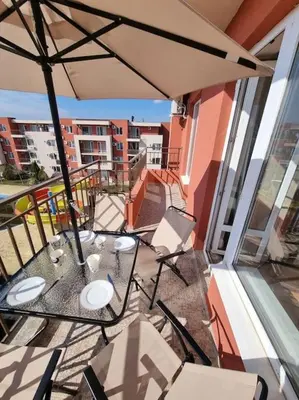 a balcony with a table and chairs and an umbrella at Sunny beach family apartment 302, Sluneční pobřeží in Sunny Beach