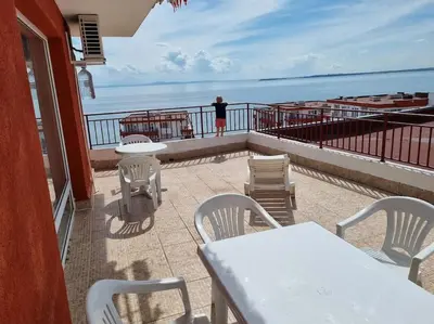 a person standing on a balcony looking at the ocean at Roof top sea view apartment 167,2ložnice,4-7 osob in Sveti Vlas