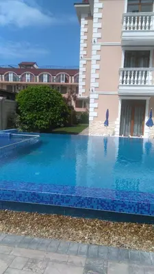 a large blue swimming pool next to a building at Guest House Aristokrat in Obzor