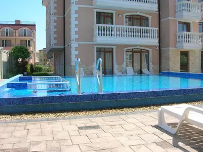 a swimming pool in front of a building at Guest House Aristokrat in Obzor