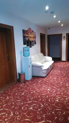 a living room with a white couch on a red carpet at Guest House Aristokrat in Obzor
