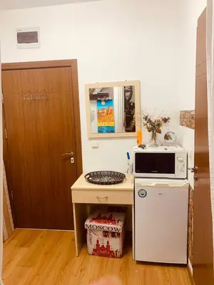 a small kitchen with a microwave and a refrigerator at Sunny view South studio Мир Авангарда in Sunny Beach