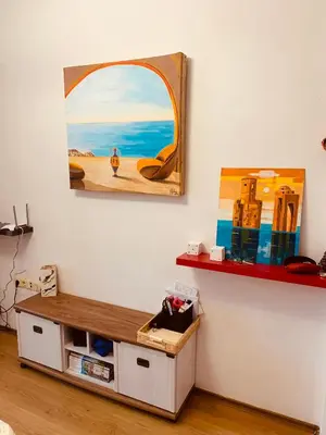 a room with a painting on the wall and a table at Студия Мир Авангарда in Sunny Beach