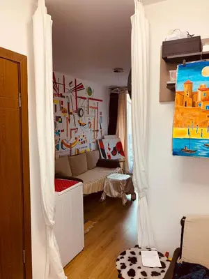 a living room with a couch and a painting on the wall at Студия Мир Авангарда in Sunny Beach