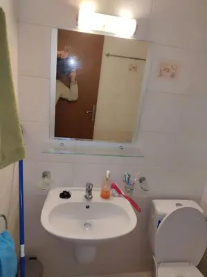 a bathroom with a sink and a toilet and a mirror at Просторная квартира в популярном комплексе in Sunny Beach