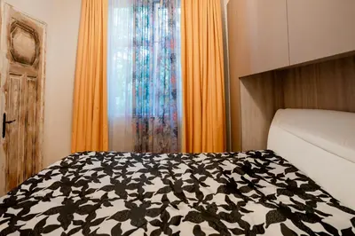 a bedroom with a bed with a black and white blanket at Elite place Suite in Varna City