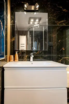 a bathroom with a white sink and a mirror at Elite place Suite in Varna City