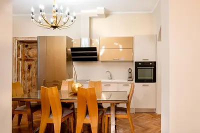 a kitchen with a table and chairs and a chandelier at Elite place Suite in Varna City