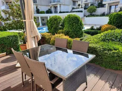 a glass table with chairs and an umbrella on a deck at Sunny Villa in Byala
