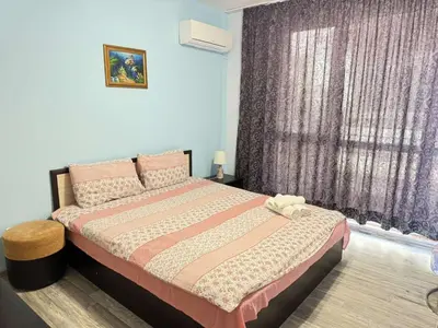 a bedroom with a bed and a purple curtain at Guest Apartment The Fabulous Sunset -Sozopol in Sozopol