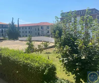 a building with a yard with trees and a building at 2 Bed Apt at Watermill Complex in Sveti Vlas