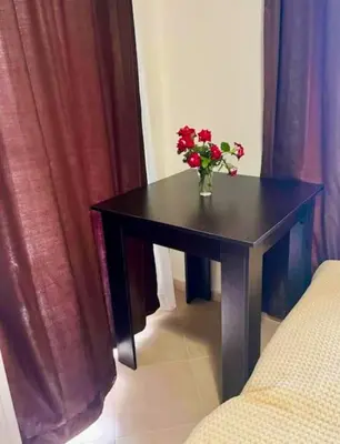 a black table with a vase of flowers on it at Апартаменты Мисаря in Sozopol