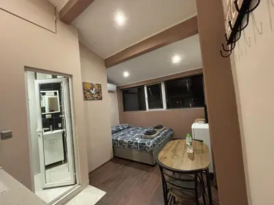 a small room with a bed and a table at GRAND STUDIO SEA GARDEN - top center in Burgas City