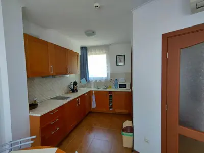a kitchen with wooden cabinets and a window at Bay View Villas apartment NONA 1C - Kosharitsa in Kosharitsa