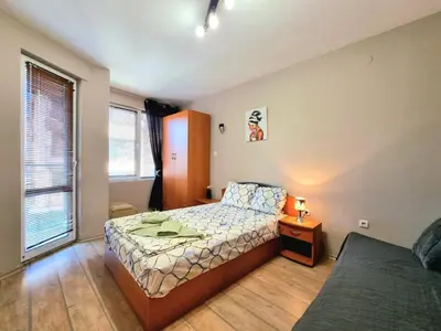 a small bedroom with a bed and a night stand at Mezonet - Sol Casa in Lazur in Burgas City