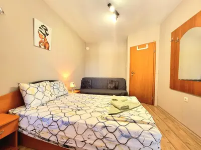 a small bedroom with a bed and a chair at Mezonet - Sol Casa in Lazur in Burgas City
