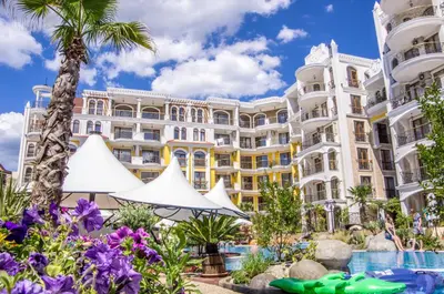 a hotel with a pool in front of a building at Harmony Suites - Monte Carlo in Sunny Beach